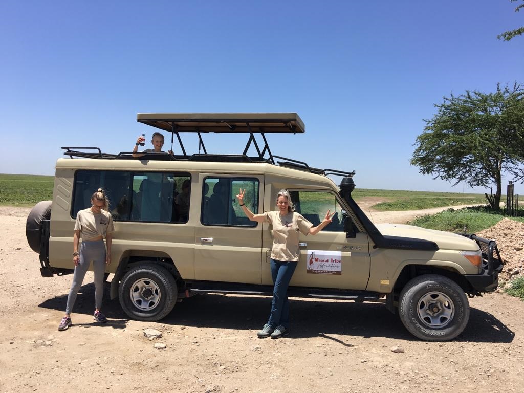 Women by safari vehicle in Tanzania
